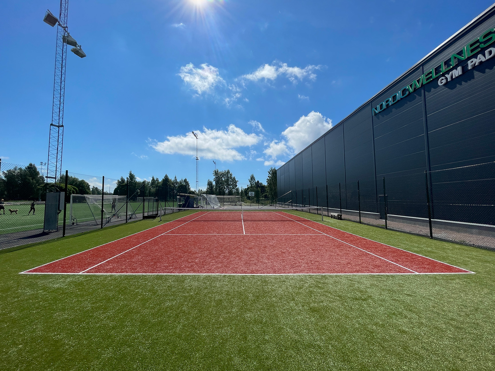 Tennisbane med kunstgress i rødt, grønt og hvitt